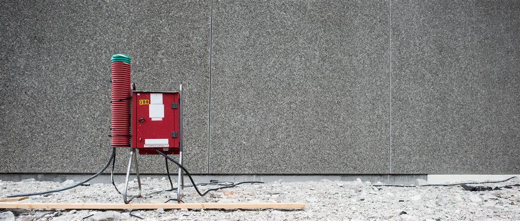 Alt=et rødt byggestrømskap stående utenfor et bygg